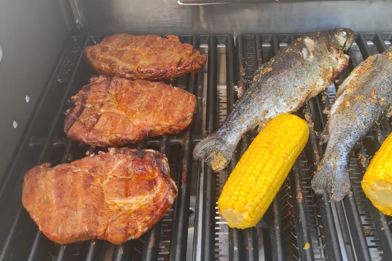 Nackensteaks, Forellen und Maiskolben auf dem Gussrost des Big FRED Deluxe