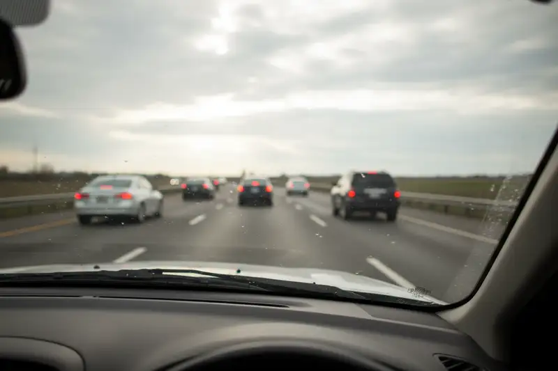 Dashcam hinter der Windschutzscheibe eines Autos bei Tageslicht mit Blick auf eine Straße