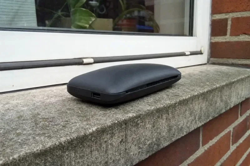 Aufgeblähte Powerbank mit gewölbtem Gehäuse auf einer Fensterbank im Freien