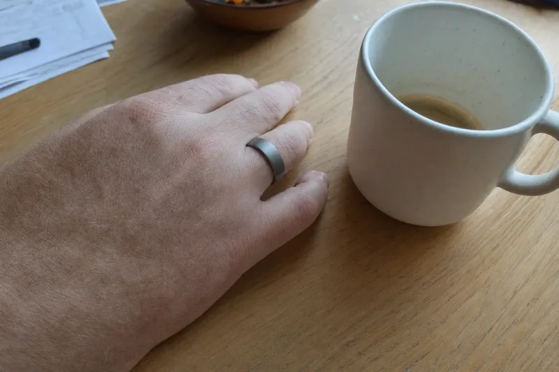 Matter Smart Ring aus Titan am Finger einer Hand, getragen im Alltag am Schreibtisch bei Tageslicht