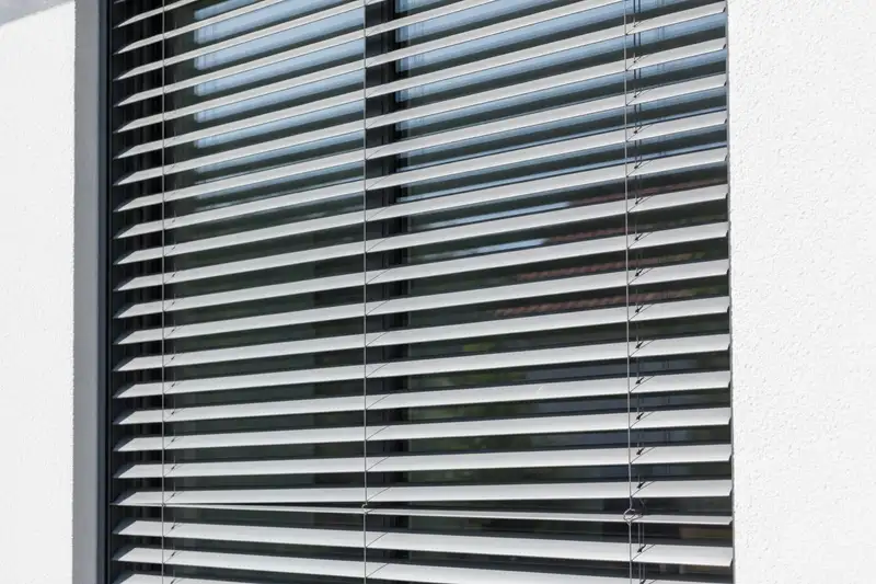 Außenliegende Raffstores an der Fensterfront eines modernen Wohnhauses
