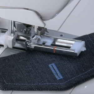 Die Singer Curvy 8770 Nähmaschine beim Knopflochnähen im Jeansstoff