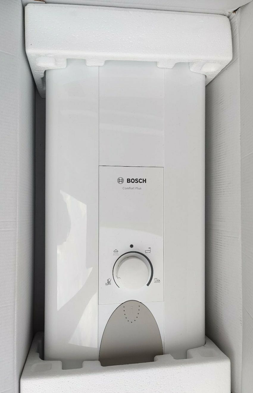 Der Bosch Tronic Comfort Plus 24/27 Durchlauferhitzer wird ausgepackt.