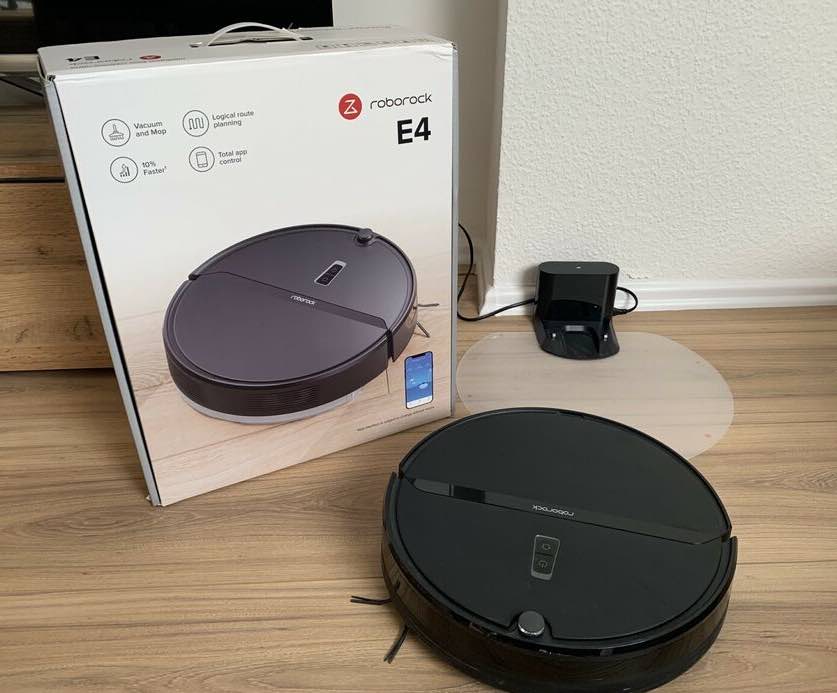 Der Roborock E4 Saug- und Wischroboter neben der Verpackung.