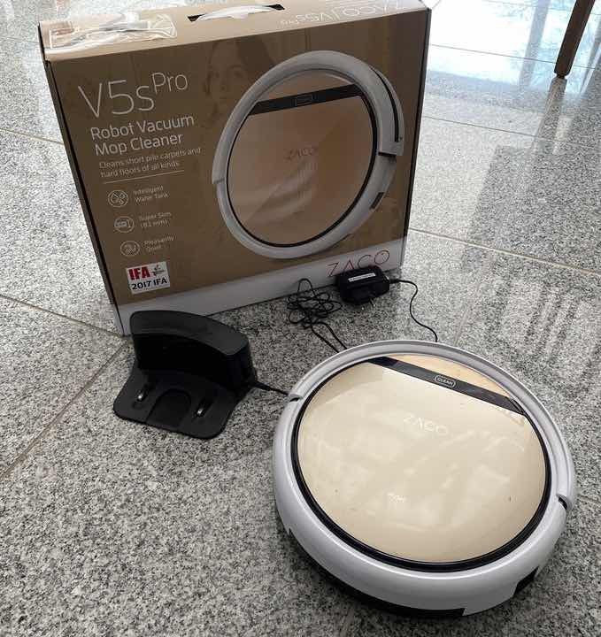 Der ZACO V5sPro Saugroboter mit Verpackung und Ladestation.