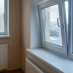 Lüften über das Fenster: Ein teures Missverständnis Zwei Fenster, eines beschlagen, eines geöffnet mit Thermometer, Blick auf verschneite Landschaft. Heizkörper unter Fenstern.