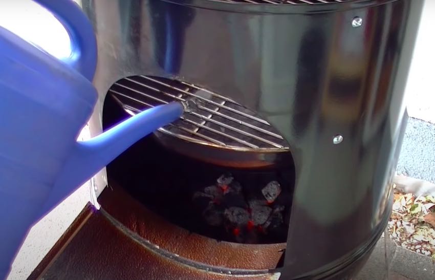 Das Befüllen der Wasserschale gestaltet sich dank der großen Türen beim Weber Smokey Mountain recht einfach.